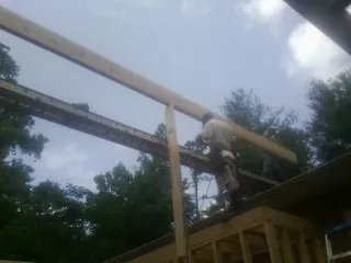Carpenter setting a ridge beam over a new addition frame — Ice Dam Removal by Roofing Brothers in North Springfield
